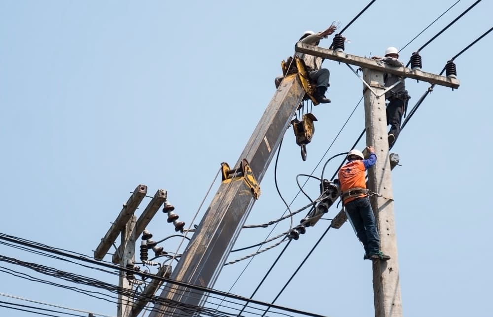 Linesmen working on an overhead electricity distribution pole
