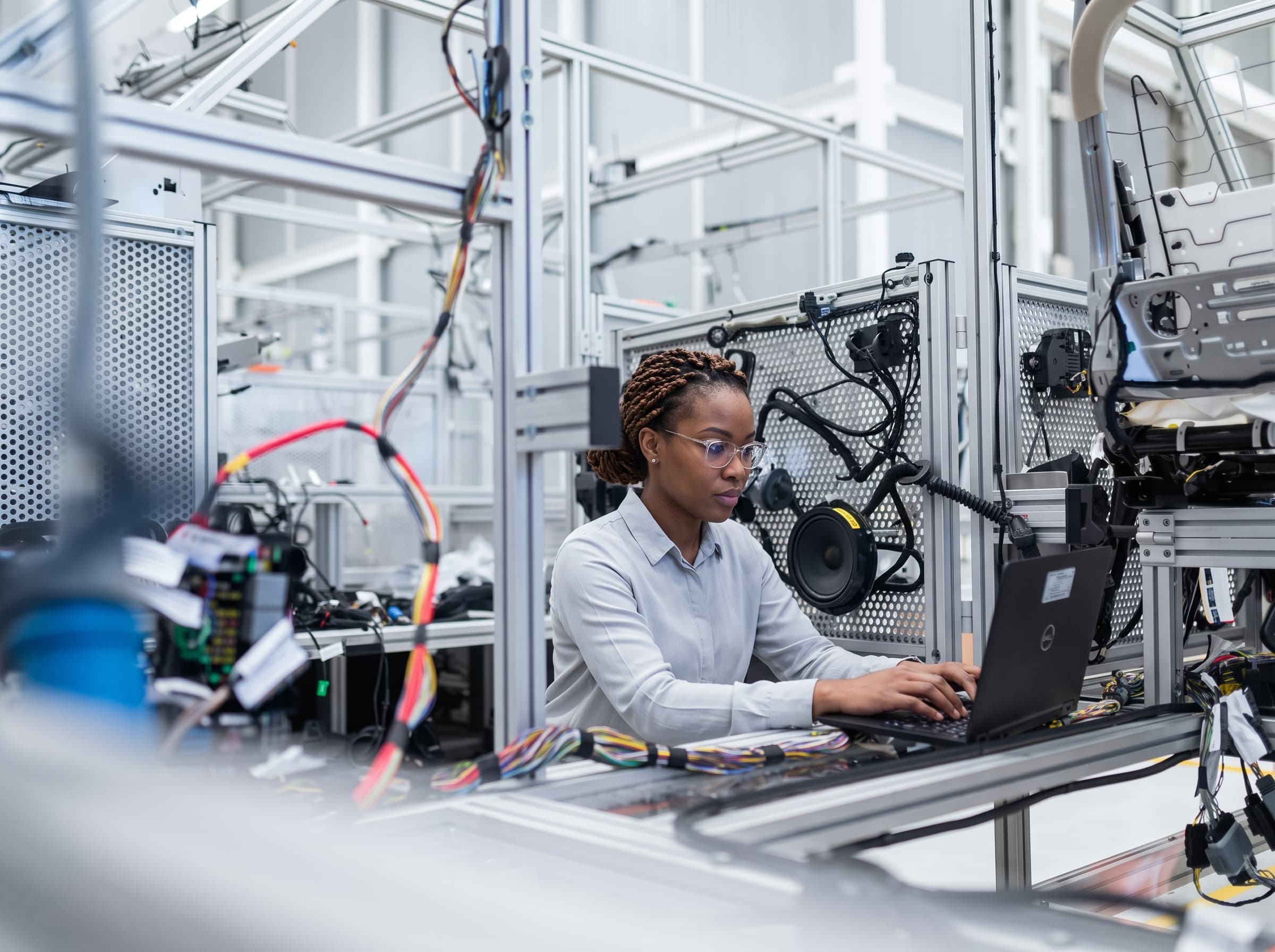 Engineer working at a laptop on a manufacturing floor